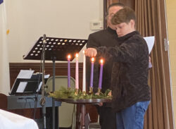 A picture of the boy lighting the candles at the church