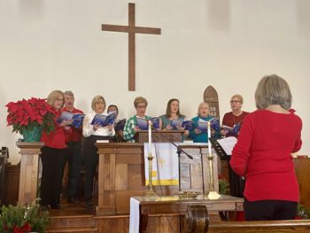 A group of people holding their books and singing