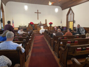 A long shot of the audience sitting on the church benches