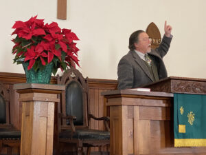 A picture of the pastor speaking in the rich valley church