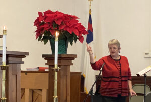 A woman speaking on the mic at the rich valley church